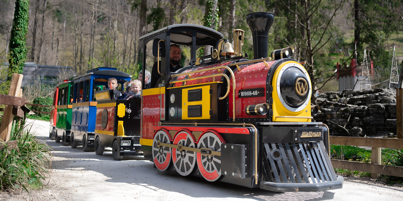 Wattman electric trackless train operating at a U.S. zoo with families aboard