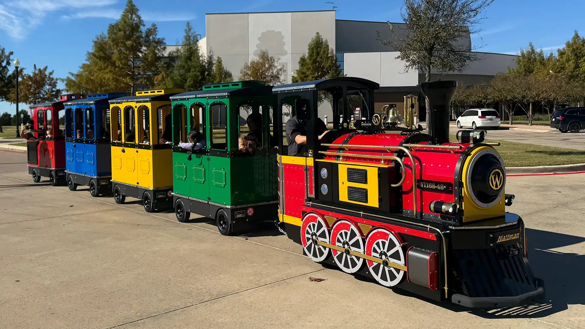 Wattman Maxi Express trackless train at a U.S. resort — colorful wagons in outdoor venue operation